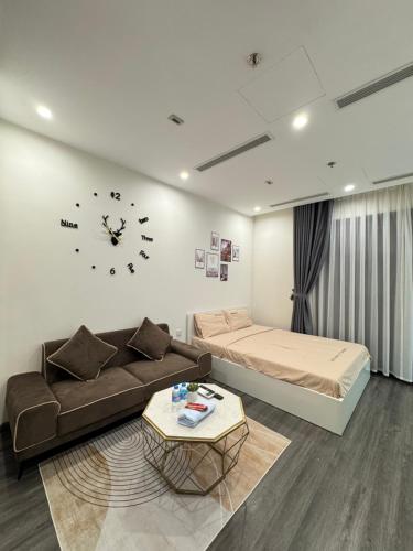 un soggiorno con un divano e un orologio a parete di Trạm Sạc Homestay-Studio sang trọng-Lãng mạn-Tầng cao views đẹp-Netflix chill a Phú Thú