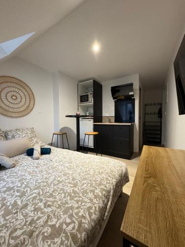 a bedroom with a large bed and a kitchen at Le studio louana Appartement neuf et discret tout confort in Aubusson