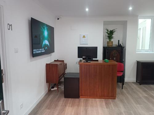 a room with a desk with a tv on a wall at Casalondres emTR77 in Lisbon