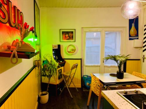 una cocina con paredes verdes y una mesa con plantas en Le Cap 80 , La suite des nostalgiques chez Ivona Vacances, en Gujan-Mestras