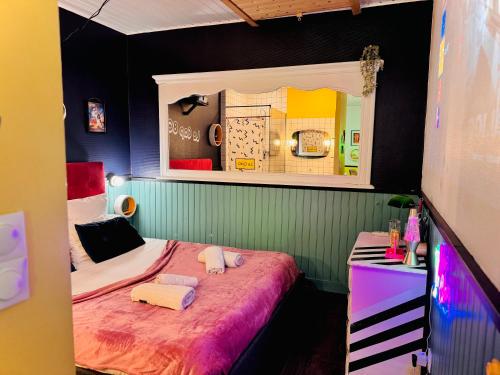 une petite chambre avec un lit et un miroir dans l'établissement Le Cap 80 , La suite des nostalgiques chez Ivona Vacances, à Gujan-Mestras