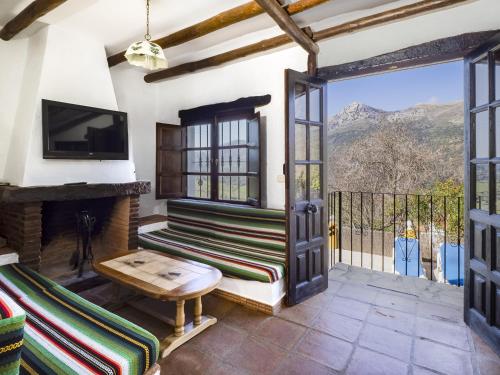 a living room with a fireplace and a sliding glass door at Cubo's Casa Rural La Albahaca de Libar in Jimera de Líbar