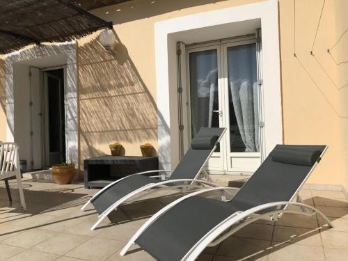a pair of chairs sitting on a patio at Maison de vacances Olonzac in Olonzac