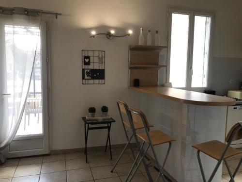 a kitchen with a bar with chairs and a table at Maison de vacances Olonzac in Olonzac
