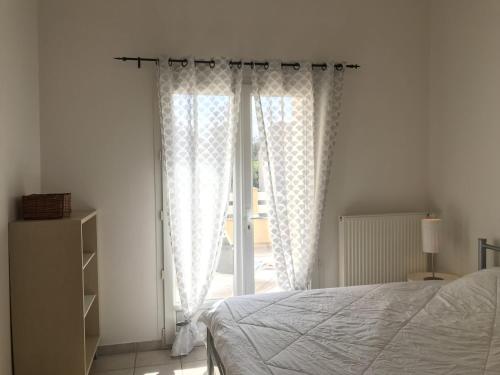 a bedroom with a bed and a window with curtains at Maison de vacances Olonzac in Olonzac
