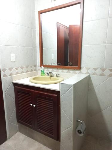 a bathroom with a sink and a mirror at El Linaje Home in Cali
