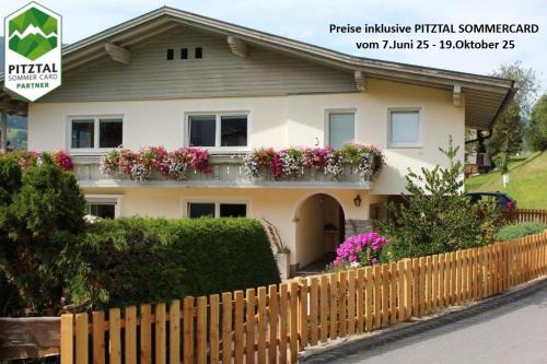 a house with a fence in front of it at Ferienwohnung Stuibenfall in Jerzens