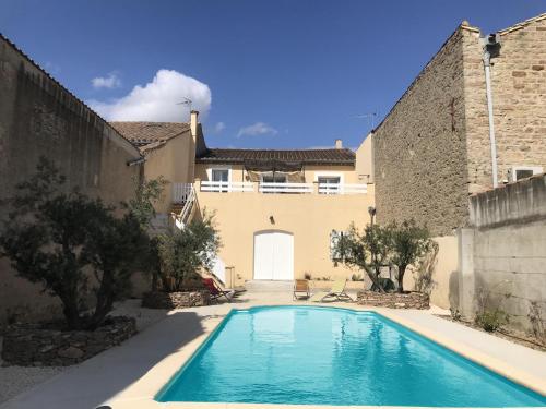 a swimming pool in the courtyard of a house at Maison de vacances Olonzac in Olonzac