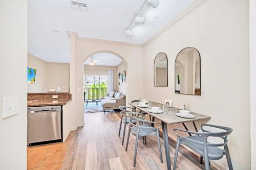 a kitchen and dining room with a table and chairs at Near Disney - 2BR Condo - Balcony Pool Hot Tub in Orlando