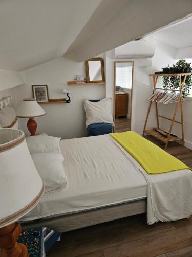 une chambre avec un grand lit avec une couverture jaune dans l'établissement Mazet, à Cavalaire-sur-Mer