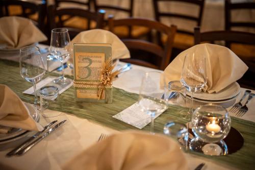 a table with plates and glasses and a candle on it at Sa Dom'e Malloru in Burcèi