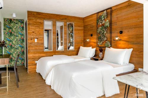 three beds in a room with wooden walls at Ponderosa Golf and Resort in Puerto Galera