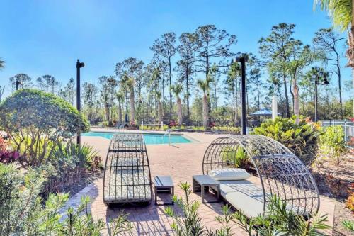 a patio with two chairs and a pool at 2BR Condo with Hot tub and pool, near Disney! in Orlando