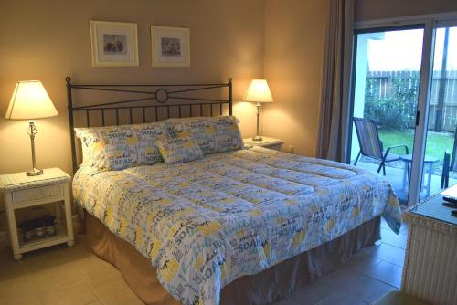 Un dormitorio con una cama, dos lámparas y un balcón. en Emerald Isle 105 by Alicia Hollis Rentals, en Fort Walton Beach