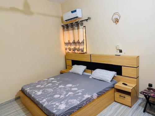 una camera da letto con un letto e una TV a parete di Les AMAZONES a Cotonou