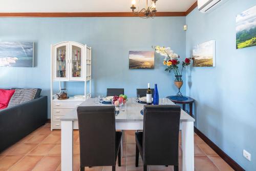 a dining room with a white table and chairs at Casa Bobo in Lagoa