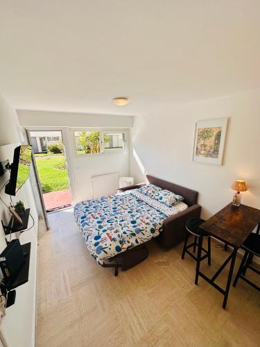 une petite chambre avec un lit et une table dans l'établissement Charmant Studio à 5 minutes des plages, à Cannes