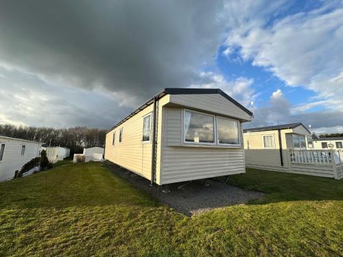 a tiny house sitting on top of a grass field at Cosy static caravan in rye! in Rye