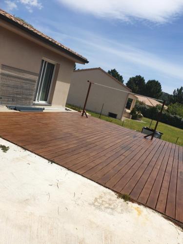 une terrasse en bois devant une maison dans l'établissement Chambre privée, à Porto-Vecchio