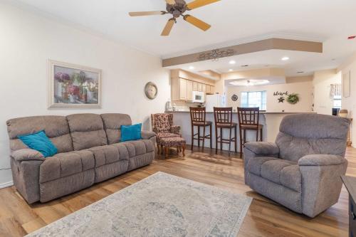 a living room with two couches and a kitchen at Greenside Hideaway - In the heart of Branson in Branson