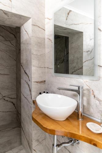 a bathroom with a white sink and a mirror at Almyra House in Adamas