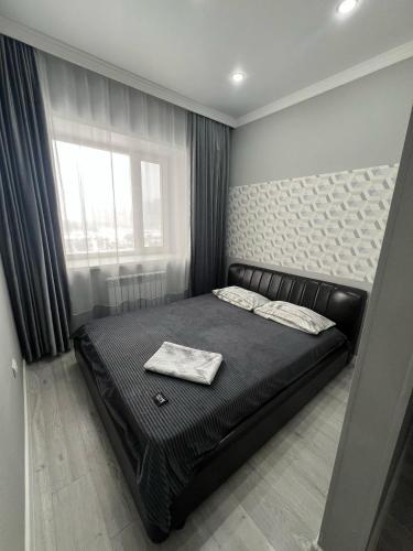 カラガンダにあるЖк Асыл Парк Юго востокのベッドルーム(黒いベッド1台、窓付)