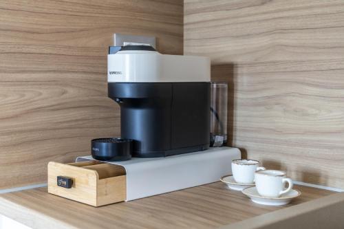 a coffee machine with two cups on a counter at Almyra House in Adamas