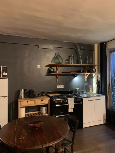 - une cuisine équipée d'une table, d'une cuisinière et d'un sidx de table dans l'établissement Loft Parisien, à Paris