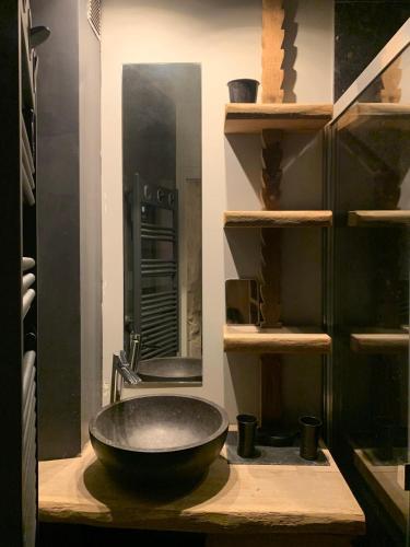 une salle de bain avec un lavabo noir et un miroir dans l'établissement Loft Parisien, à Paris