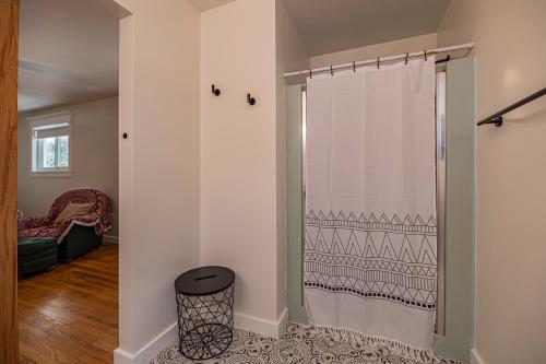 a bathroom with a shower curtain and a stool at Southern Pines Gem with 2 Master-King Suites in Southern Pines