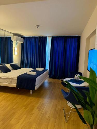 a bedroom with two beds and blue curtains at Beautiful apartments near the sea - ORBI CITY N4 in Batumi