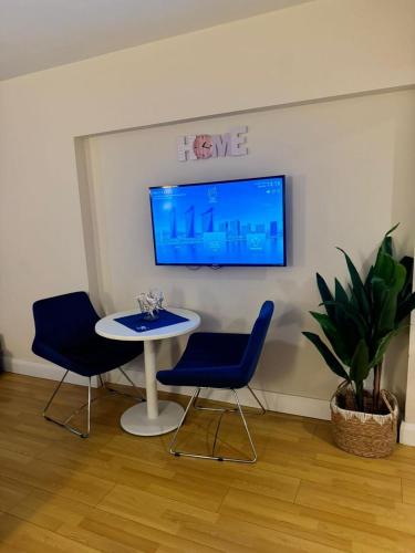 a room with a table and two chairs and a tv at Beautiful apartments near the sea - ORBI CITY N4 in Batumi