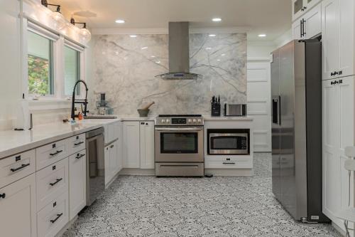 a kitchen with white cabinets and a stove top oven at Southern Pines Gem with 2 Master-King Suites in Southern Pines
