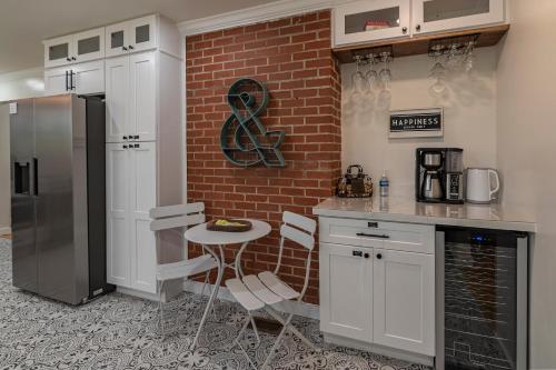 a kitchen with white cabinets and a brick wall at Southern Pines Gem with 2 Master-King Suites in Southern Pines