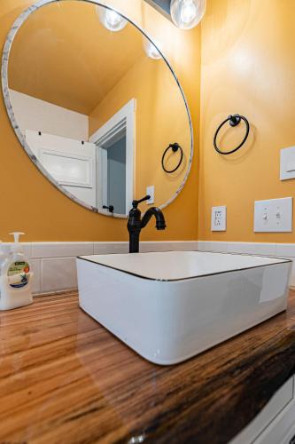 a bathroom with a white sink and a mirror at Southern Pines Gem with 2 Master-King Suites in Southern Pines