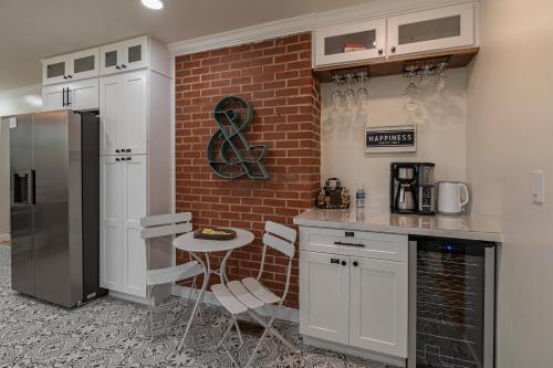 a kitchen with white cabinets and a brick wall at Southern Pines Gem with 2 Master-King Suites in Southern Pines