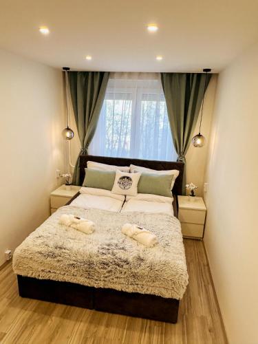 a bedroom with a large bed with two towels on it at Palace City Apartman,T13, AC, Klima in Székesfehérvár