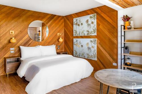 a bedroom with a white bed and a table at Ponderosa Golf and Resort in Puerto Galera