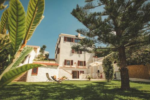 a person sitting in a chair in front of a house at Villa Lucia in Alghero