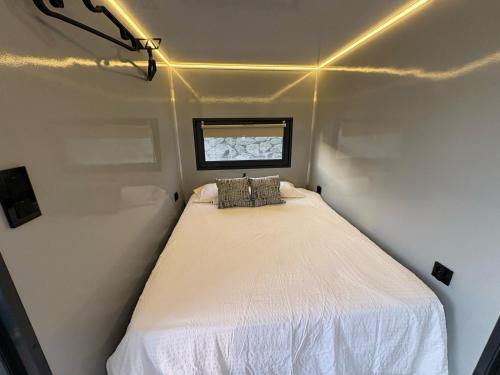 圣玛丽亚港The Boathouse Company - Casa flotante experience - Real Club Náutico, El Puerto de Santa María的一个小房间的小床,设有窗户