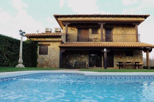 a house and a swimming pool in front of a house at La Toscana in Los Cortijos