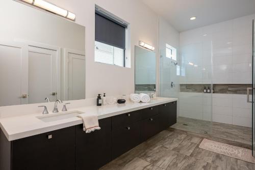 a bathroom with a sink and a large mirror at Space City - Prof Design, Game Room, King BD in Houston