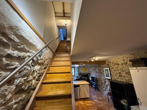 a staircase in a house with a stone wall at Maison de village in Yvoire