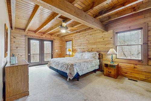 a bedroom with a bed in a room with wooden walls at Other Side of the Mountain in New Tazewell