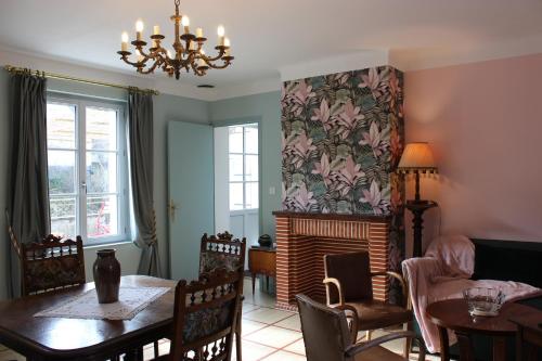 un salon avec une table et une cheminée dans l'établissement La Georginette, à Saint-Georges-sur-Cher