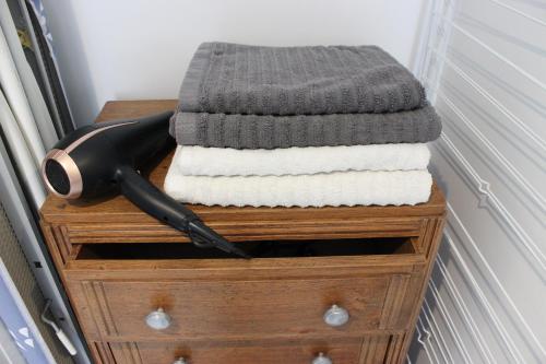 une pile de serviettes sur une commode avec un couteau dans l'établissement La Georginette, à Saint-Georges-sur-Cher