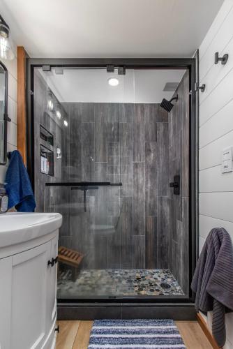 a shower with a glass door in a bathroom at Tee & Ski Cabin | Mt Rainier, White Pass in Packwood