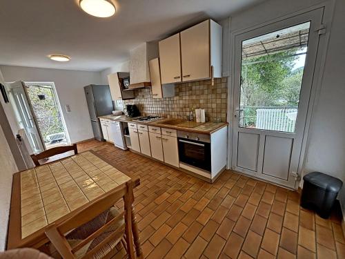 a kitchen with a wooden table and a table and a dining room at Maison accueillante, Les Vans, vue sur montagne, grand jardin in Les Vans