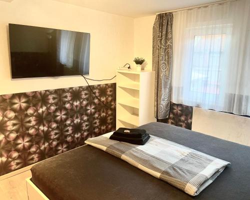 a bedroom with a tv and a table with a blanket at Moderne Wohnung mit großer Küche und Bad in Stadtilm