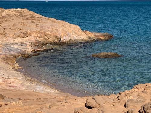 a beach with some rocks and the water at Miral Resort in Ain Sokhna